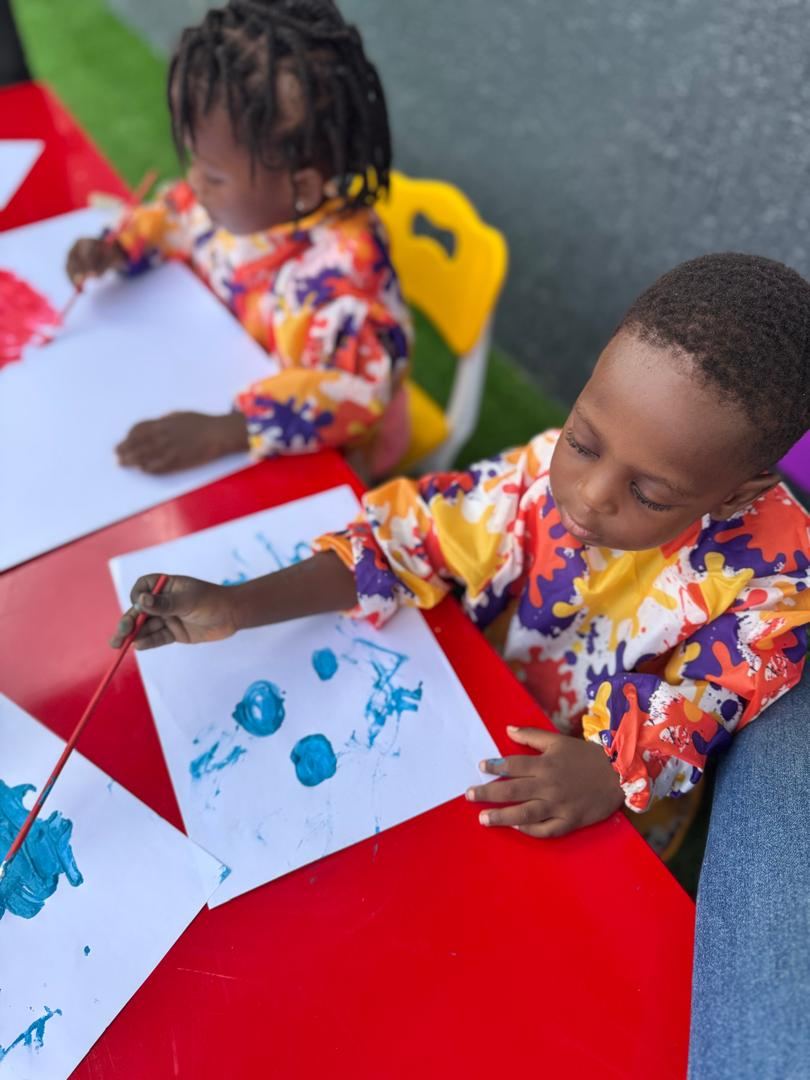 Young child painting with blue paint